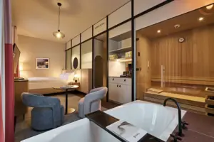 Ein Zimmer mit einer Badewanne, einer Sauna und einem Bett.