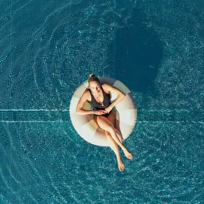 Frau sitzt auf einem Schwimmreifen im Pool