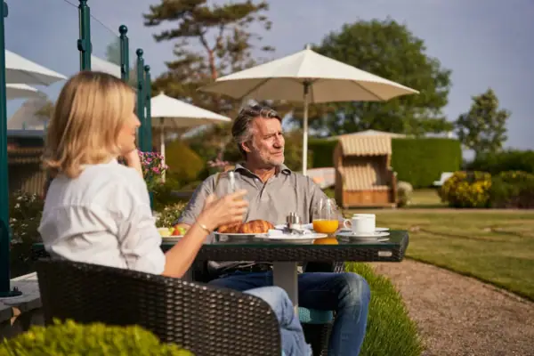 Gäste beim Frühstück auf der Ostseeterrasse mit Strandkörben im Hintergrund