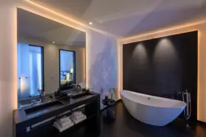 Badezimmer mit Badewanne und Waschbecken, ausgestattet mit modernen Armaturen und einem Spiegel.