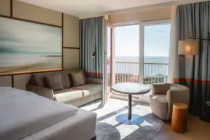 Hotelzimmer mit Bett, Couch und Tisch.