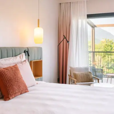 Ein Bett mit Kissen und einer Lampe in einem Zimmer mit Balkon.