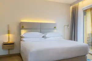 Ein Bett in einem Zimmer mit eleganter Bettwäsche und Kissen.