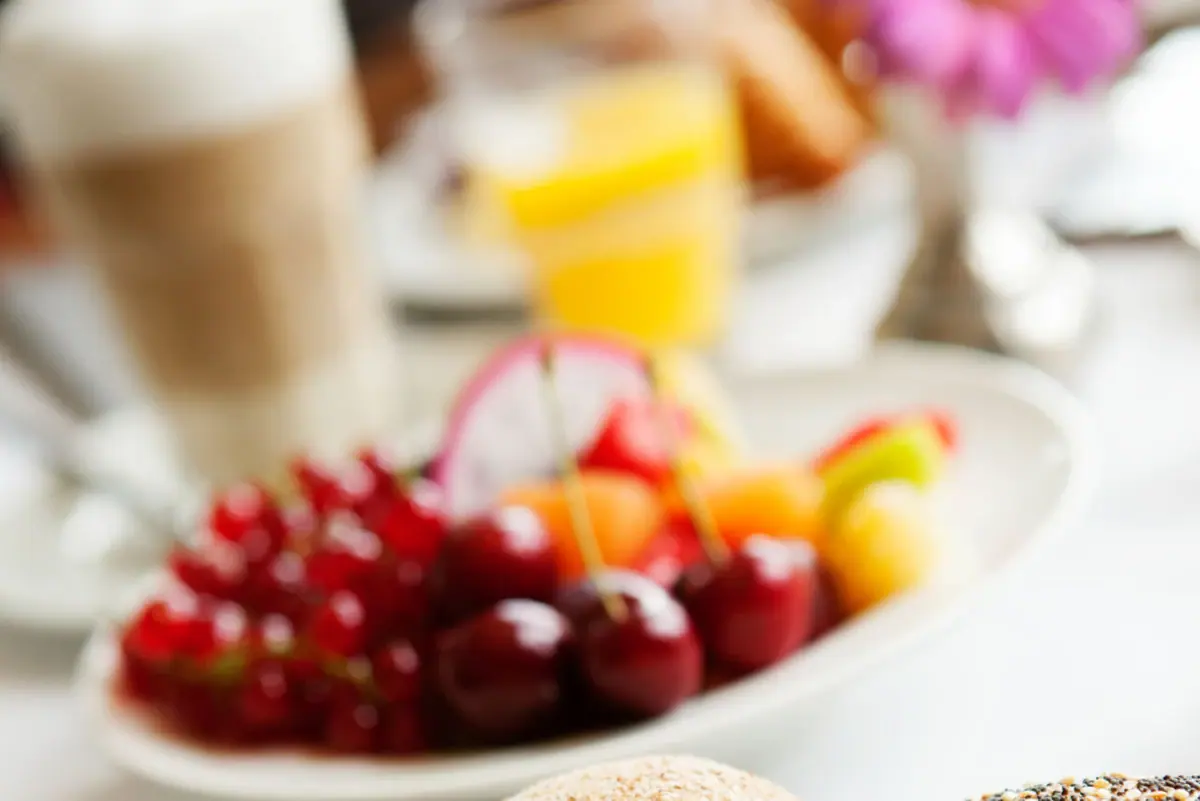 Ein Teller mit Essen und Obst auf einem Tisch.