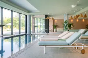 Ein Pool mit Liegestühlen im Vordergrund und einem weiteren Pool im Hintergrund.