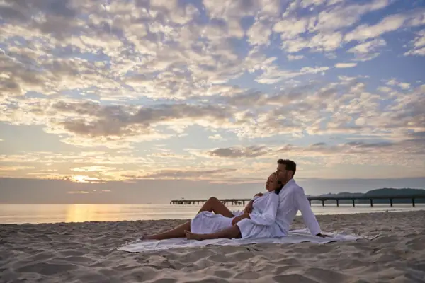 Ein Mann und eine Frau sitzen am Strand.