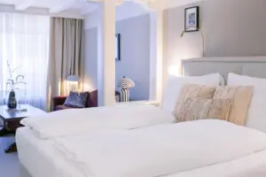 Bett mit Kissen und Bettwäsche in einem stilvoll eingerichteten Zimmer.