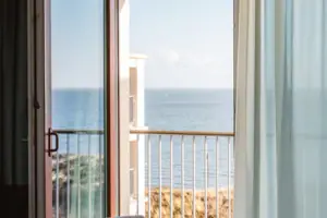 Ein Zimmer mit Balkon und Blick auf das Meer.