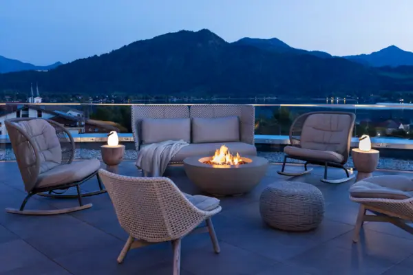 Eine Terrasse mit einem Feuerstelle und Stühlen auf einem Balkon.
