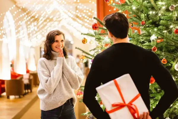 Ein Mann und eine Frau stehen neben einem Weihnachtsbaum.